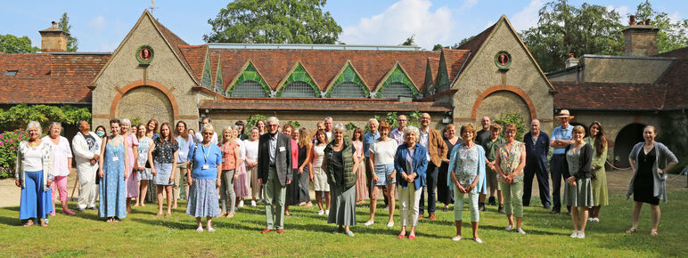 A group photo of the Watts Gallery volunteers stood on the Historic Galleries lawn in the summer