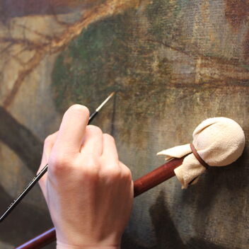 Close up of conserver's hand painting