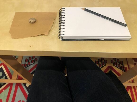 Sketchbook with pebble beside