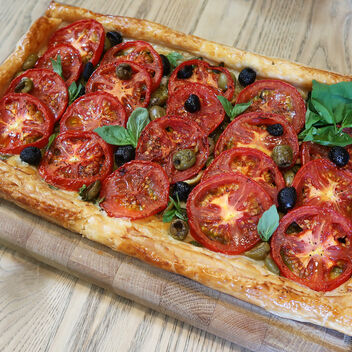 Tomato and olive tart decorated with basil leaves