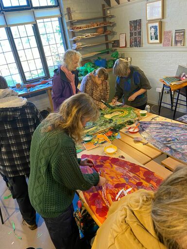 A group of volunteers gathered in the Foyle collaging the phone box angels