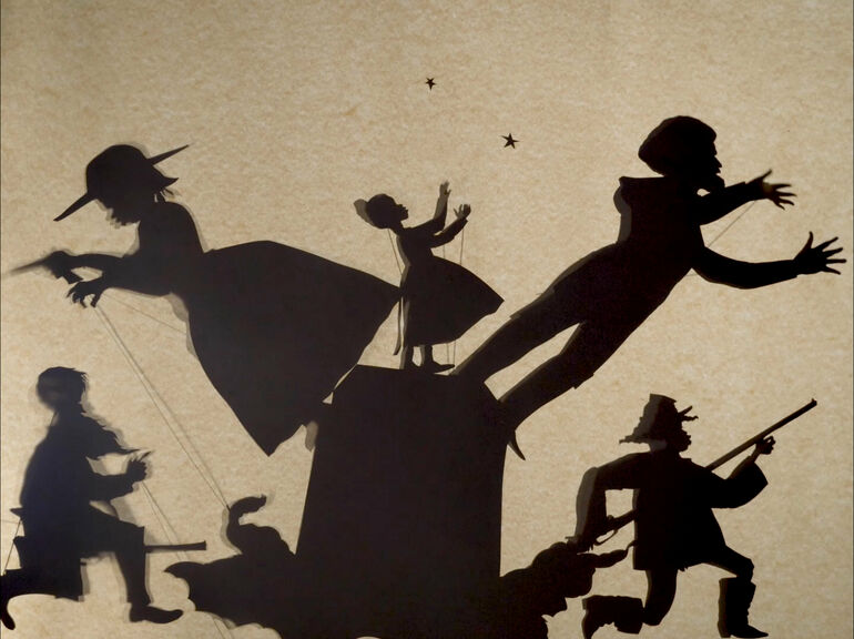 Cut-paper silhouettes of various figures on a brown background