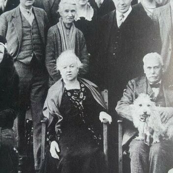 a black and white photograph of a group of people standing and sitting next to each other