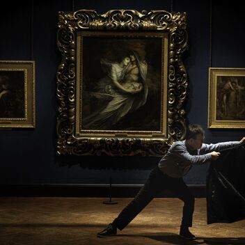 Dancer holding a jacket in a historic gallery setting