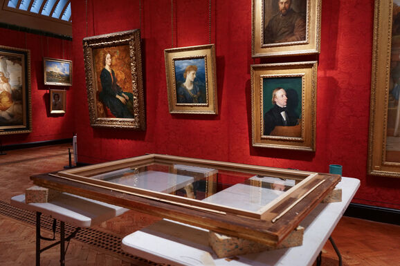 Photo inside Watts Gallery of a frame placed on a table, ready for the painting to be fitted.