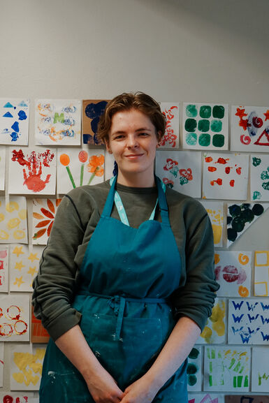 Portrait of a girl with short brown hair wearing a blue apron