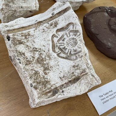 Photo of a fragment of a Compton Pottery mould with a Tudor rose on it