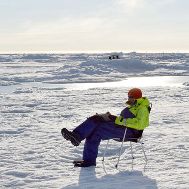 Photo of a man sitting on a chair in the North Pole sketching