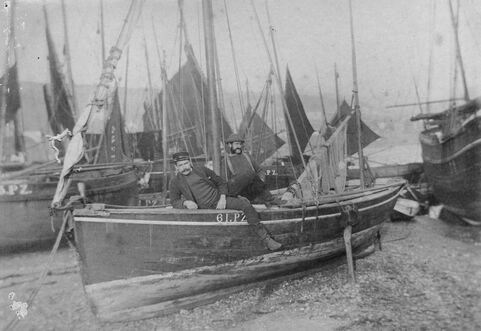 Black and white photo of two men on a small sailing boat