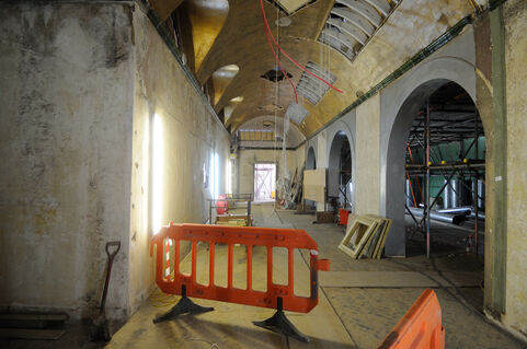 A room in a construction phase, with bare concrete walls and scaffolding