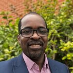 Photo of Ulric Neblett-Leigh, man with glasses and beard in a suit