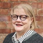 Lady with dark round glasses and blonde hair