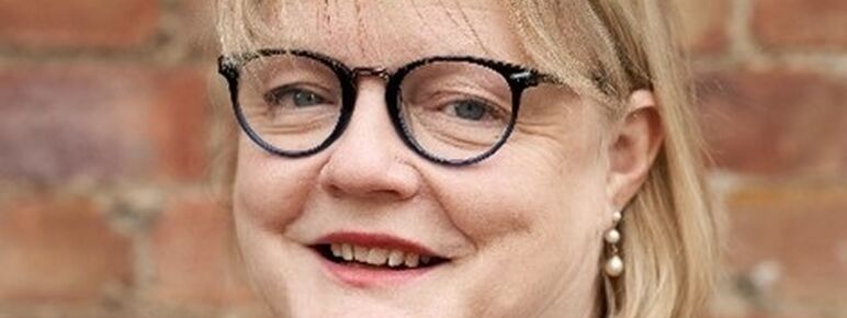 Lady with dark round glasses and blonde hair