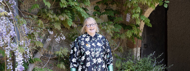 A photo of Sarah King, a lady with short blonde hair wearing glasses and a patterned shirt