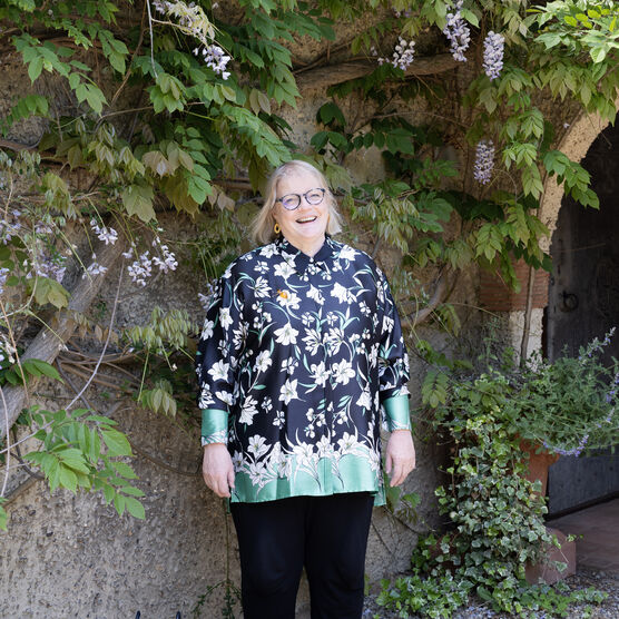 A photo of Sarah King, a lady with short blonde hair wearing glasses and a patterned shirt