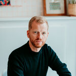 Matthew looks to camera with his arms folded