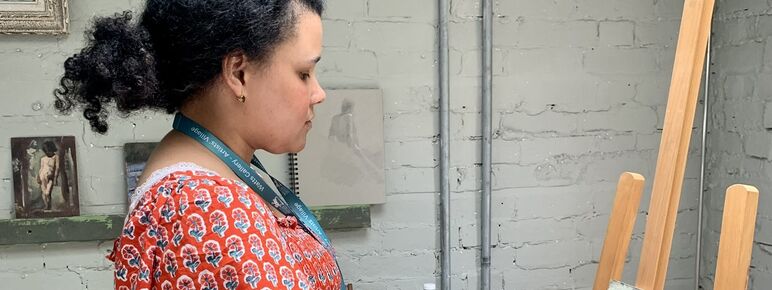 Nneka painting on an easel