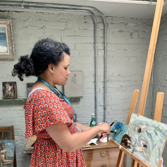 Nneka painting on an easel