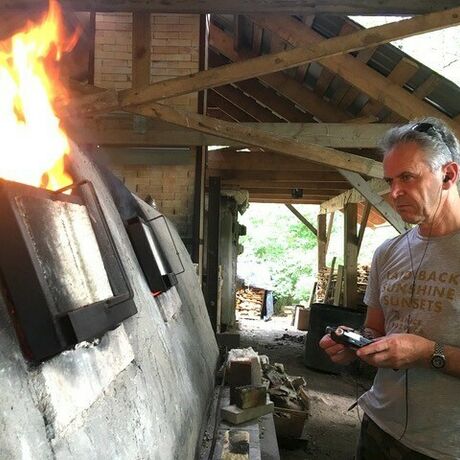 Photo of Joseph Young in front of a furnace recording the sound