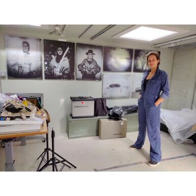Photo of artist Emma Brown wearing blue overalls in an art studio