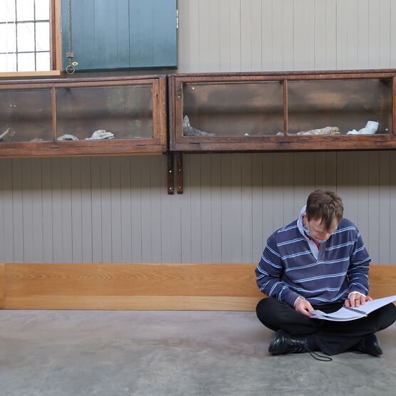 A man sits on the floor in the gallery
