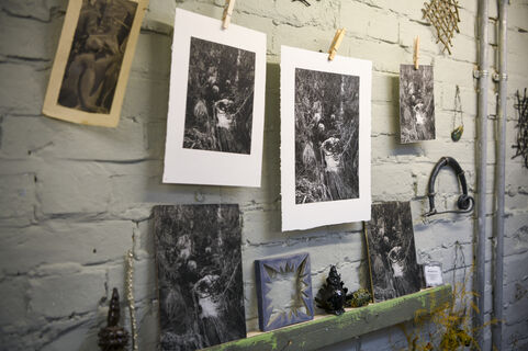 Black and white photos are hung up by pegs on a string in the Artist in Residence studio
