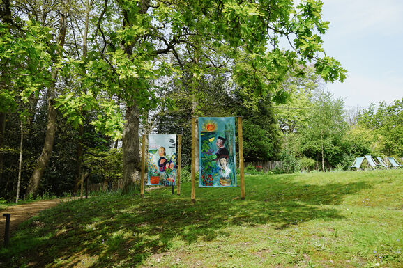 Photo of two paintings on the Limnerslease lawn at Watts Gallery, featuring portraits of George and Mary Watts