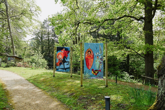 Photo of two paintings on the Limnerslease lawn at Watts Gallery, featuring paintings of some iconic works by George and Mary Watts