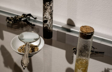 Installation photo of a magnifying glass, a small bottle and a trinket tray