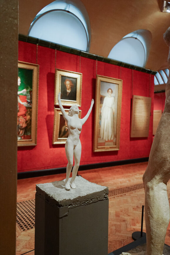 Small sculpture of a nude figure with her arms in the air exuding the feeling of joy