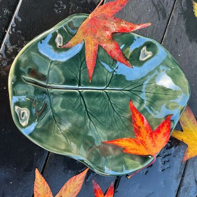A ceramic green platter shaped like a leaf