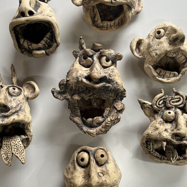 A collection of ceramic faces with unusual expressions
