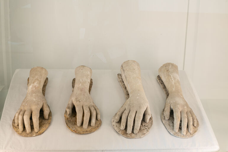 Four casts of hands in a case