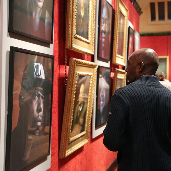 Man looks at portraits in gallery