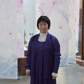 A Japanese woman with short dark hair looks towards the camera
