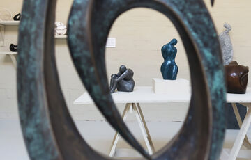A shot of two sculptures taken through the centre of a third during the 2022 Figure and Form exhibition