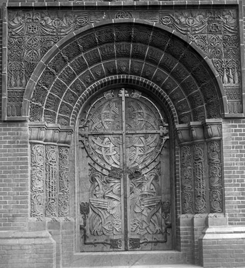 Black and white photo of arched, decorated door