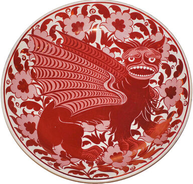 Red and white plate decorated with a Chinese dragon surrounded by flowers