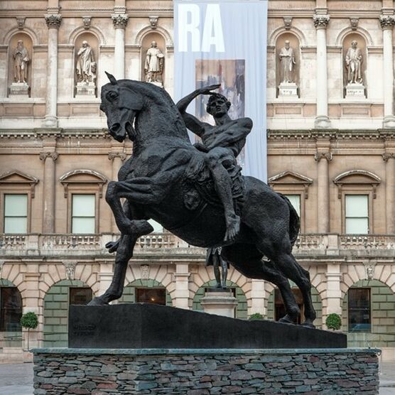Bronze statue of a man on a horse outside the RA