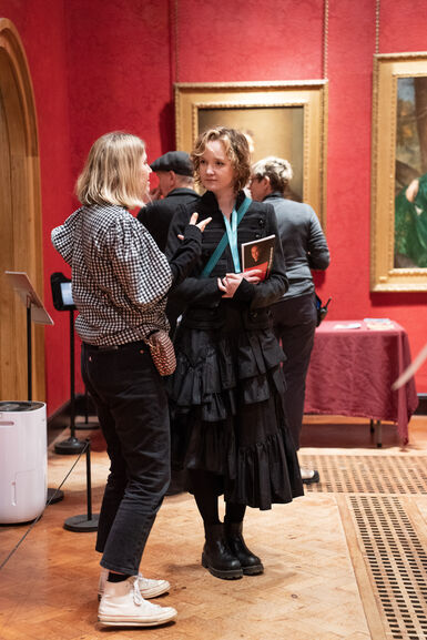A photograph of two women standing chatting in the historic galleries