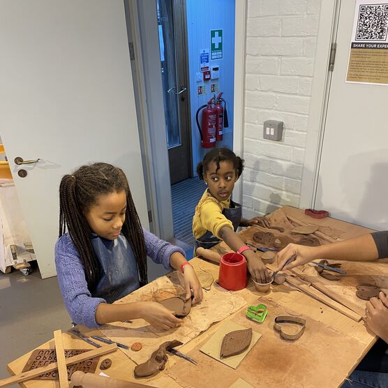 A young girl and young boy make using clay