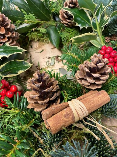 Christmas wreath with pinecones, berries and cinnamon sticks