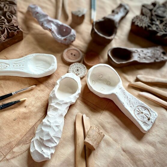 A photograph of a selection of ceramics laid out on a table with tools