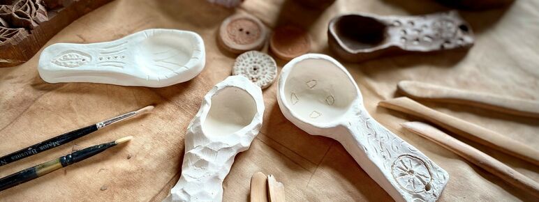 A photograph of a selection of ceramics laid out on a table with tools