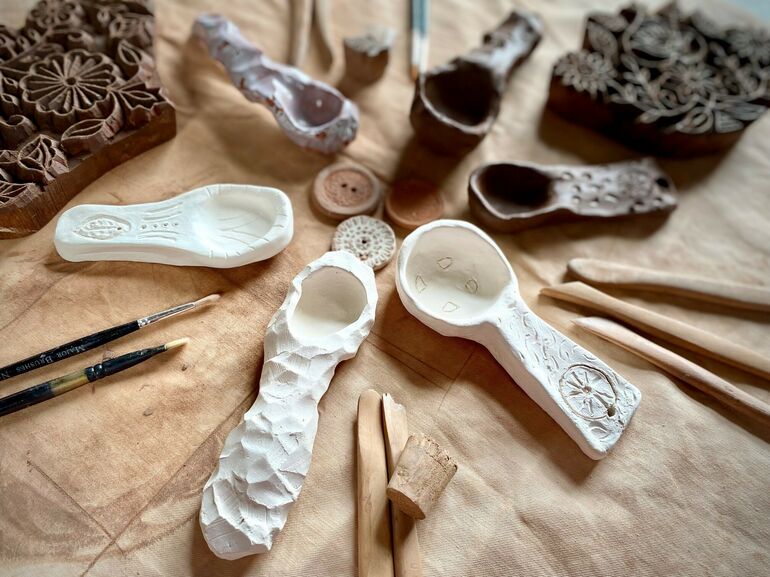 A photograph of a selection of ceramics laid out on a table with tools