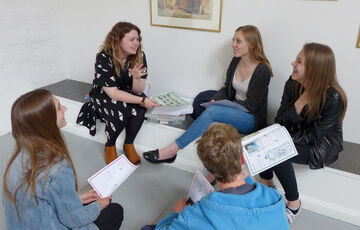 A group of students chat in a circle