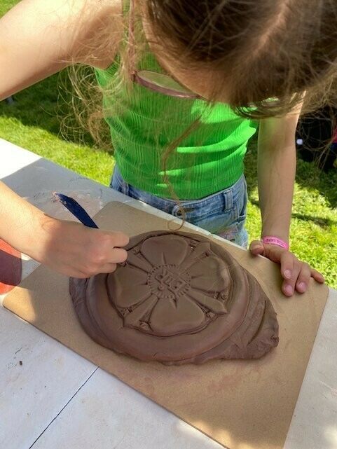 Child makes clay tile