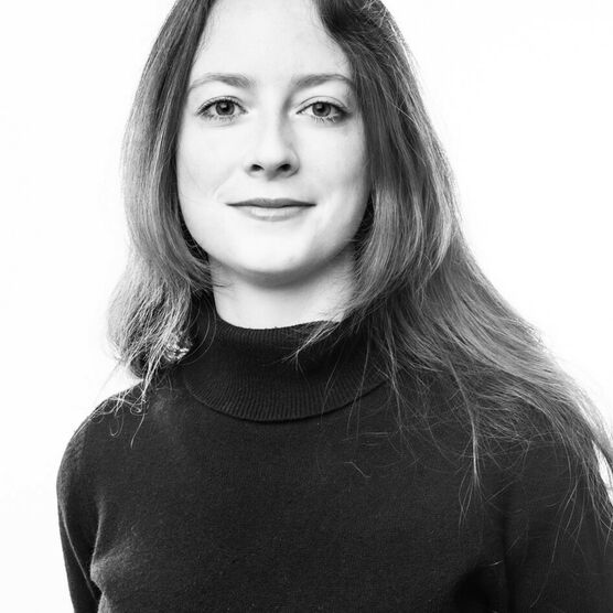 Black and white photo of Louise Hopkins, an adult woman with long dark hair wearing a black top