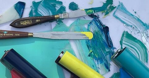 Photo of blue ink, palette knives and lino rollers placed on a surface