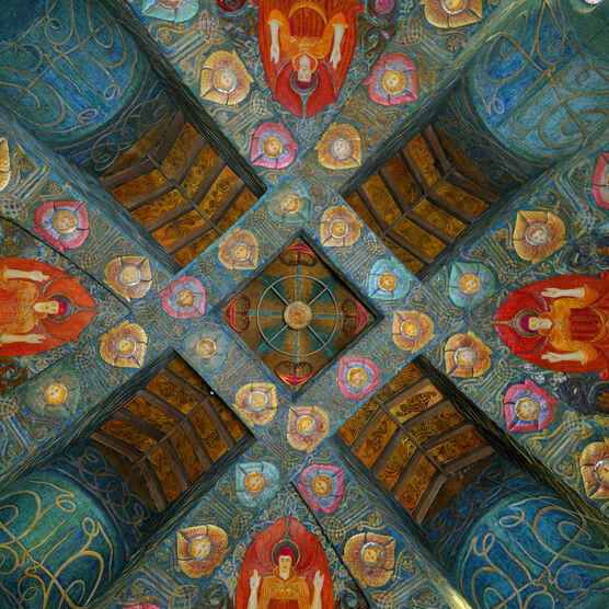 Looking up at the colourful highly-decorated chapel ceiling. It features blue turquoise panels and four red angels.
